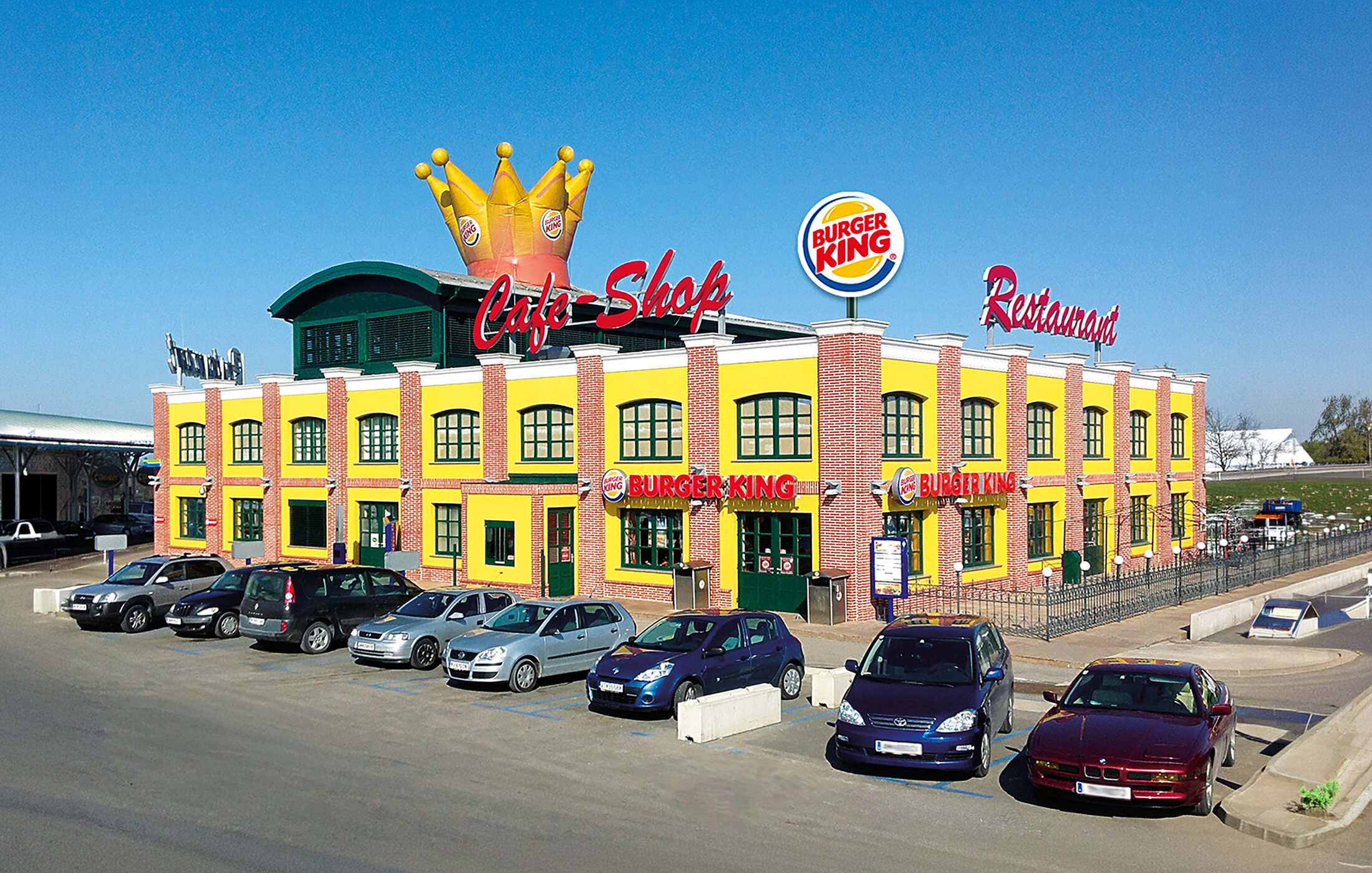 Blick auf den Oldtimer-Standort in Oed mit parkenden Autos im Vordergrund.