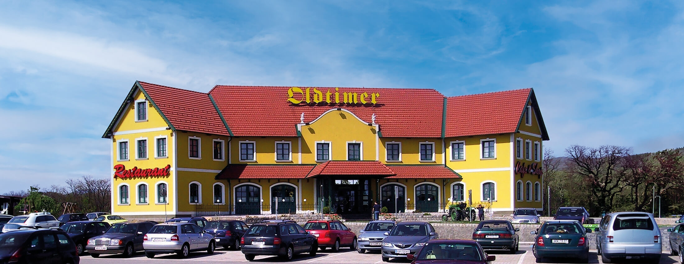 Blick auf den Oldtimer Standort in Zöbern, parkende Autos im Vordergrund.