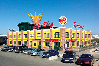 Blick auf den Oldtimer STandort Oed, mit parkenden Autos davor.