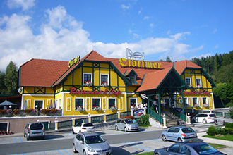 Blick auf die Oldtimer Raststation auf der Pack, parkende Autos im Vordergrund.