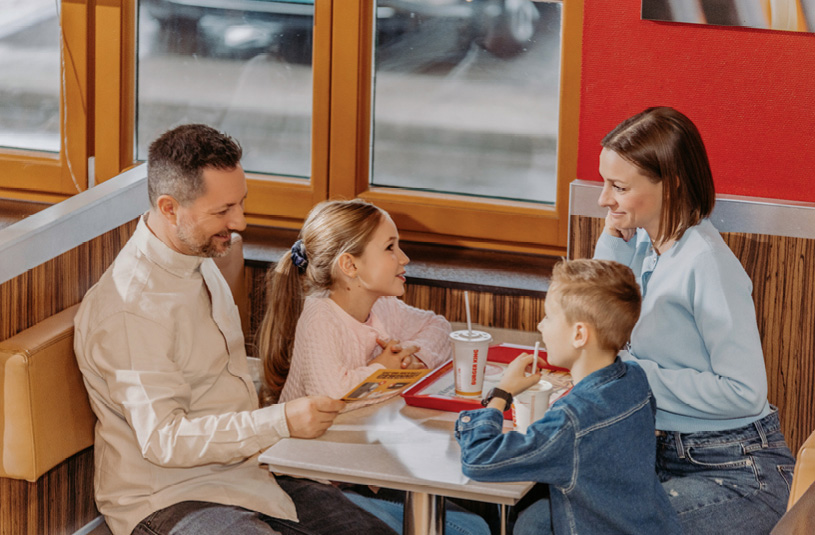 Eine Familie beim gemeinsamen Essen im Burger Kind Restaurant in Oed.